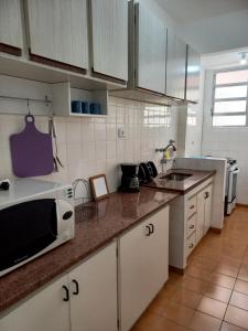 a kitchen with a microwave and a counter top at Santos frente ao mar in Santos