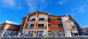 una casa de madera con una valla delante en Appt à Ancelle pied des pistes, en Ancelle
