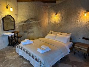 a bedroom with a bed with two towels on it at Kale House Nar in Nevşehir