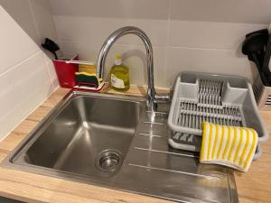 a kitchen sink with a dish drying rack next to it at Le Azzar in Melun