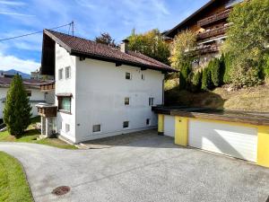 a white house with two garage doors on a driveway at Haus St. Georg in Seefeld in Tirol