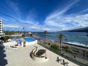 uma vista para a praia e para o oceano a partir de um edifício em Le terrazze 11 em Puerto de la Cruz