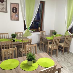 a dining room with wooden tables and green plates at Apartamenty Puk Puk in Mrągowo