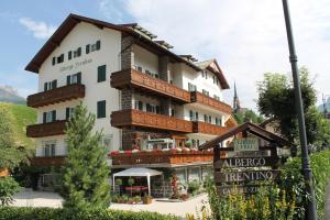 un gran edificio con un cartel delante en Albergo Trentino, en Moena
