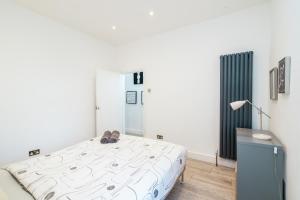 Un dormitorio con una cama con zapatos. en Modern 2 bed apartment close to Westfield Stratford mall with garden en Londres