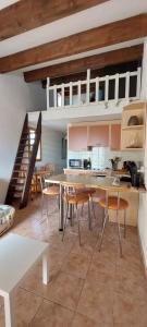 - une cuisine avec une table et des chaises dans la chambre dans l'établissement Agréable petite maison 2 chambres, de 48m2 sans vis-à-vis et parking privatif, au Cap d'Agde