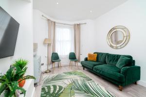 sala de estar con sofá verde y sillas verdes en Modern 2 bed apartment close to Westfield Stratford mall with garden en Londres