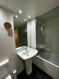 a bathroom with a sink and a mirror and a tub at AT home Santo Domingo in Guadalajara