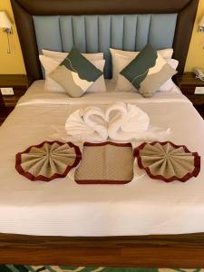 1 cama con sábanas blancas y almohadas con arcos en Green valley boutique en Paro