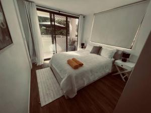 een slaapkamer met een wit bed en een groot raam bij Beach Pad Private Town house Sea Views Dual living 5 Beds in Redcliffe