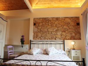 a bedroom with a bed and a stone wall at Villa Alba in Marciana Marina