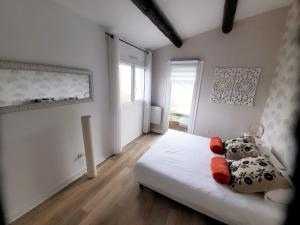 1 dormitorio con cama blanca y ventana en The Cosy House, en Périgny