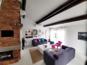 sala de estar con 2 sofás y chimenea en The Cosy House, en Périgny