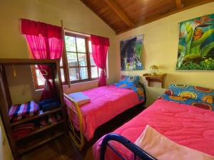 2 Betten in einem Zimmer mit rosa Bettwäsche in der Unterkunft LODGE NATAN in Quito