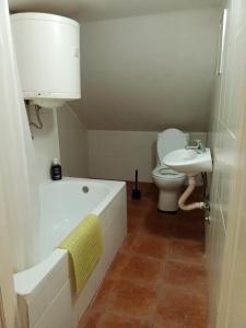 ein Badezimmer mit einer Badewanne, einem WC und einem Waschbecken in der Unterkunft Airport ROOMS NIKKI in Belgrad