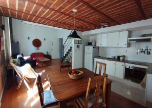 cocina y sala de estar con mesa de madera y sillas en Zabalita, hermoso y cálido loft en la Ciudad Vieja, en Montevideo