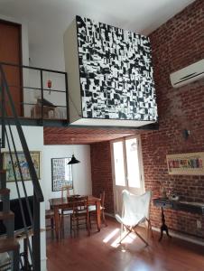 a living room with a table and chairs and a brick wall at Zabalita, hermoso y cálido loft en la Ciudad Vieja in Montevideo