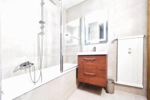 uma casa de banho com um chuveiro, um lavatório e um espelho. em Brin de Mousse I 49 m I Balcony I Peace and greenery em Crans-Montana