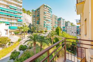 an apartment balcony with palm trees and buildings at Appartamento vista mare di Marco in Spotorno