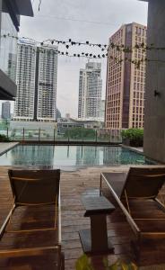 d'une terrasse avec 2 chaises et une table et certains bâtiments dans l'établissement Anggun Residence KL Malaysia, à Kuala Lumpur