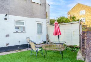 a patio with a table and chairs and an umbrella at Modern 2 bed apartment close to Westfield Stratford mall with garden in London