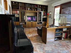 uma sala de estar com um sofá e uma televisão em Villa degli Ulivi em Massa Marittima