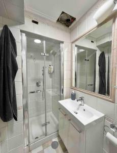 ein Bad mit einer Dusche, einem Waschbecken und einem Spiegel in der Unterkunft Don Vincenzo’s House in Neapel