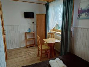 a small room with a small table and a window at Noclegi U Reni in Białka Tatrzańska