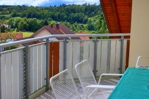 een paar stoelen op een balkon met een hek bij Ferienwohnung Preisinger in Gammertingen