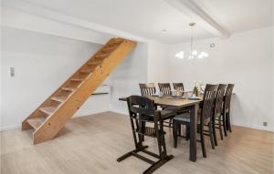a dining room with a table and chairs and a staircase at Awesome Home In Rudkbing With Wifi in Rudkøbing