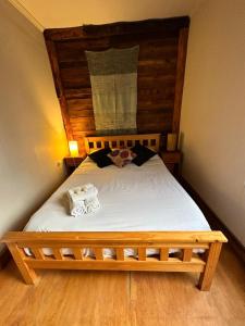 1 dormitorio con 1 cama con 2 toallas en Santuario Patagonia en El Bolsón