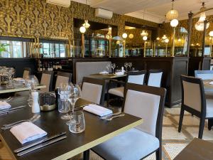 ヴィムルーにあるHôtel De Wimereuxのテーブルと椅子のあるレストラン、バー