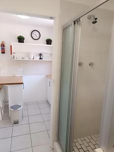 a bathroom with a shower and a clock on the wall at NoulAnouk's Corner in Cape Town