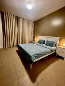 a bedroom with a large bed with blue sheets at مارينا KAEC in King Abdullah Economic City