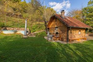 una pequeña casa de madera con bañera en un patio en Rudnica Hill Lodge - Happy Rentals, en Podčetrtek
