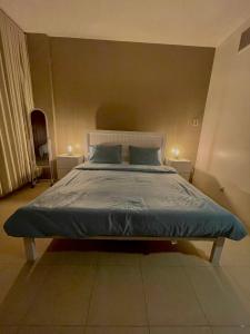 a bedroom with a bed with blue sheets on it at مارينا KAEC in King Abdullah Economic City