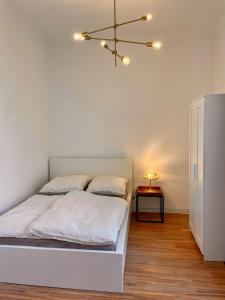 a bedroom with a bed with white sheets and a lamp at Ferienwohnung unter den Linden in Malente
