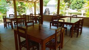 a dining room with wooden tables and chairs at Grand Okka Hotel in Buttala