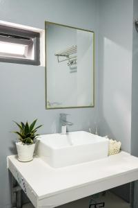 La salle de bains est pourvue d'un lavabo blanc et d'un miroir. dans l'établissement Cá Homestay-Cao Bằng, à Cao Bằng