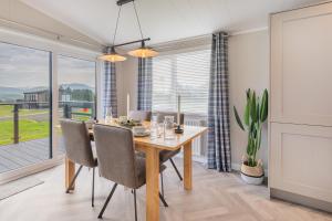 a dining room with a table and chairs and a window at Oak Tree Timber Holiday Lodge in Bassenthwaite