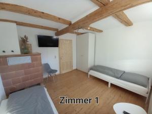 een kleine kamer met een bed en een televisie bij Pension Kleinschmidt in Urbach
