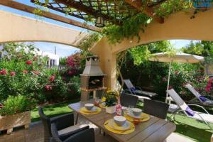 eine Terrasse mit Tisch und Stühlen und einem Sonnenschirm in der Unterkunft Oleanda in Port d'Alcúdia + 16 Fotos