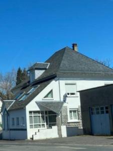 a white house with a black roof at Appart la Percep in La Tour-dʼAuvergne