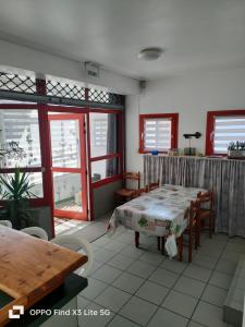 a room with a table and chairs and windows at Appart la Percep in La Tour-dʼAuvergne