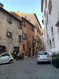 two cars parked on a cobblestone street with buildings at Navona Rhome in Rome