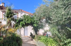 a white house with trees and plants in front of it at Studio avec jardin à 10 mn à pied du centre ville in Toulouse