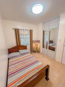Isabela Province Staycation House في Cordon: غرفة نوم مع سرير مع اللوح الأمامي الخشبي