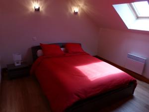 a bedroom with a red bed with two red pillows at Les Baillis in Villegenon