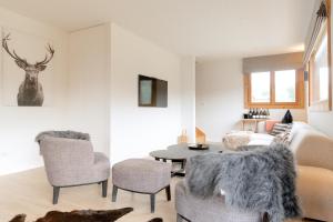 een woonkamer met een bank, een tafel en stoelen bij Bright & elegant stand alone chalet - 8 ppl - Vois Le Mont in Les Gets