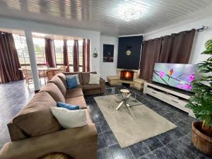a living room with a couch and a flat screen tv at Hollywood villa in Campanário